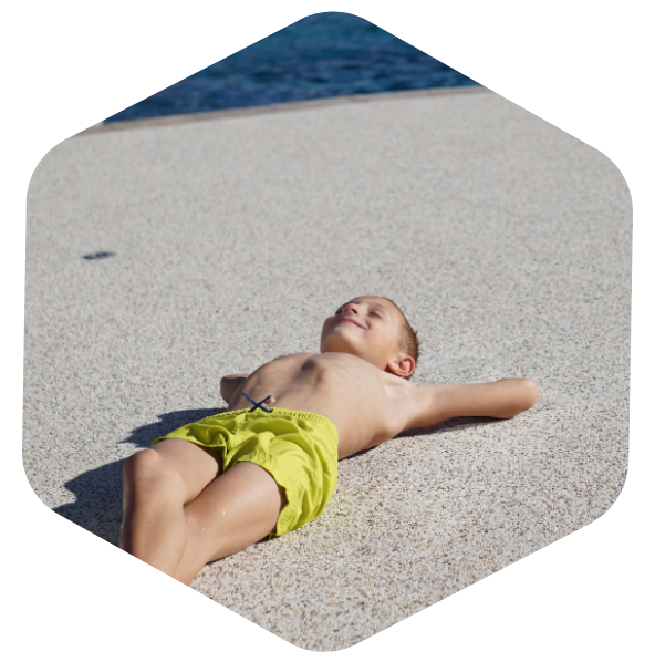 young child lying on Softroc® pool deck
