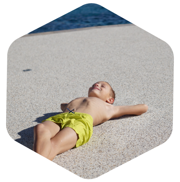 young child lying on Softroc® pool deck